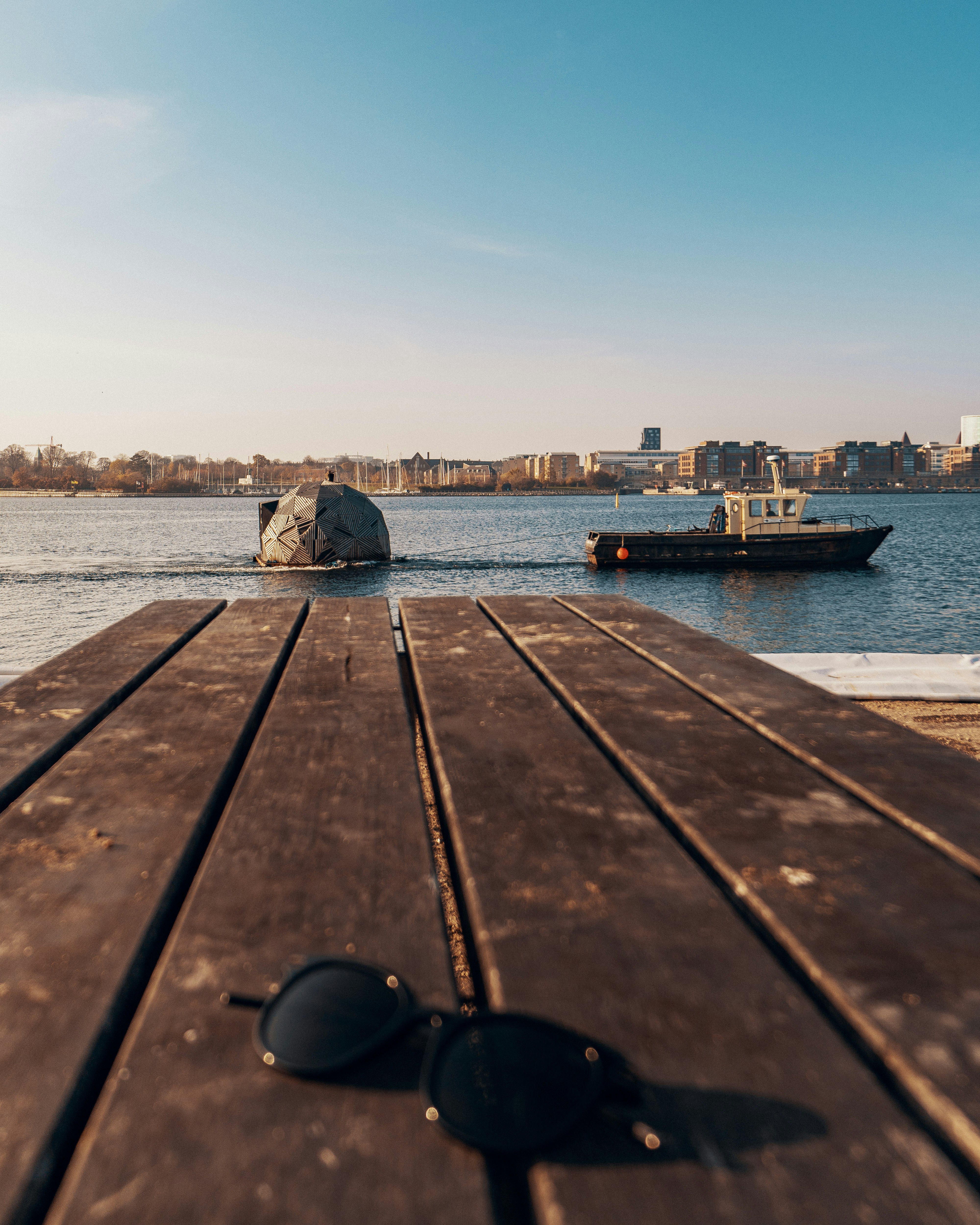 black framed sunglasses on brown wooden surface